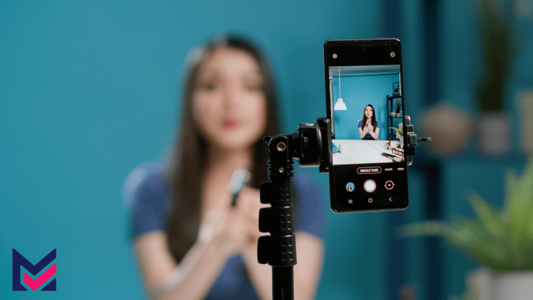 Woman making content she loves, filming in front of a backdrop with her phone on a tripod